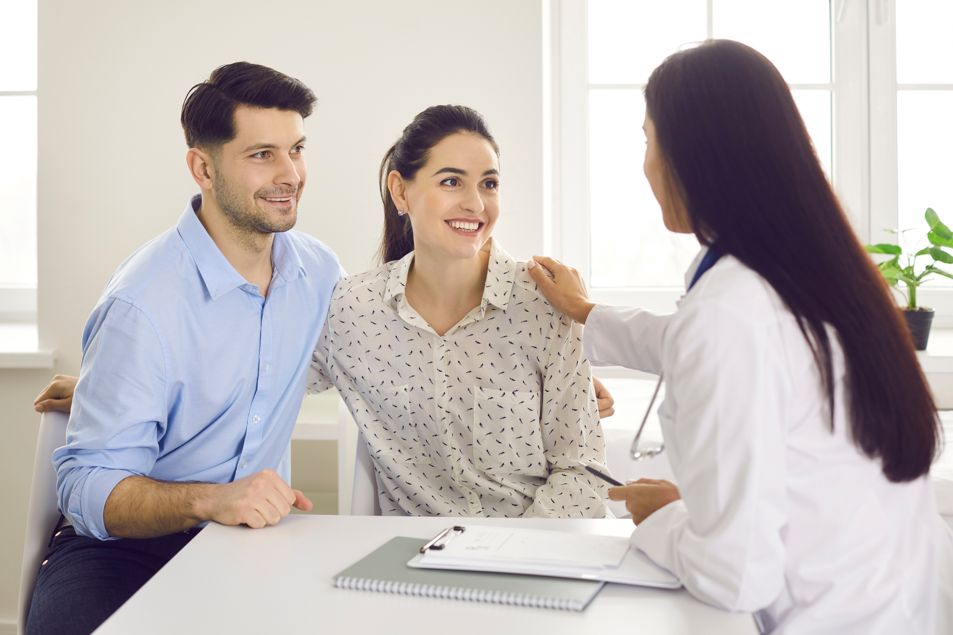 Happy young couple planning pregnancy and visiting their family practitioner together